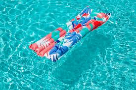 Bestway Matelas Gonflable Fashion Multicolour flottant sur une piscine lors d’une journée ensoleillée.